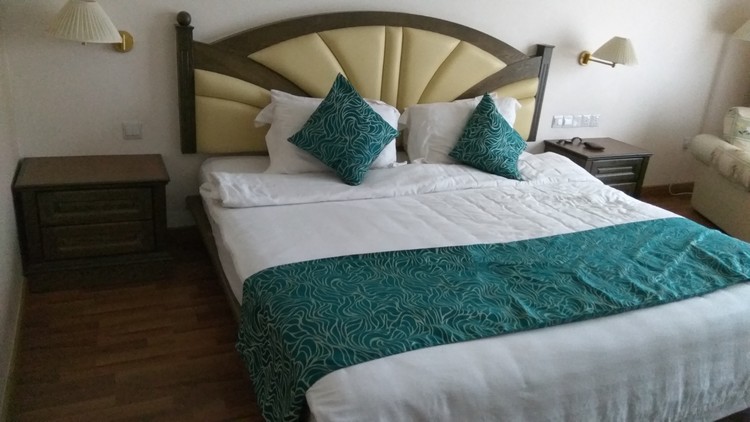 Pandangan katil dalam bilik Century Pines Resort jenis Deluxe